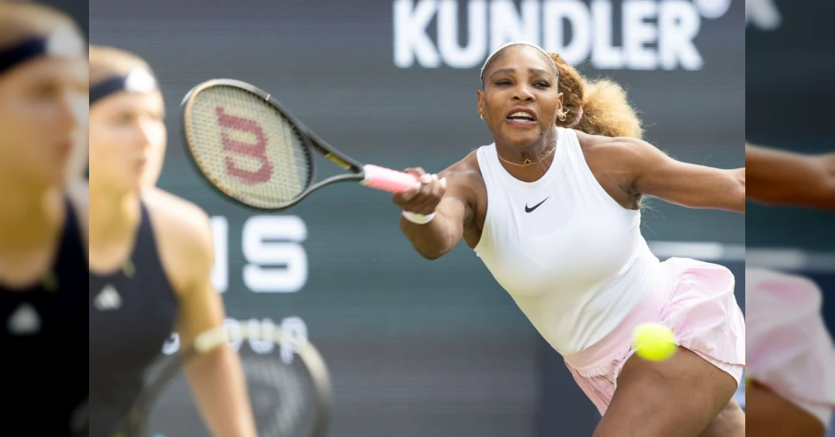 Serena Williams sorride mentre impugna una racchetta sull'erba di Wimbledon