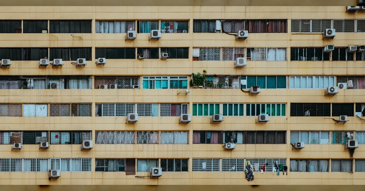 Condizionatore installato sul davanzale di una finestra in un palazzo condominiale, estate, diritto dei proprietari