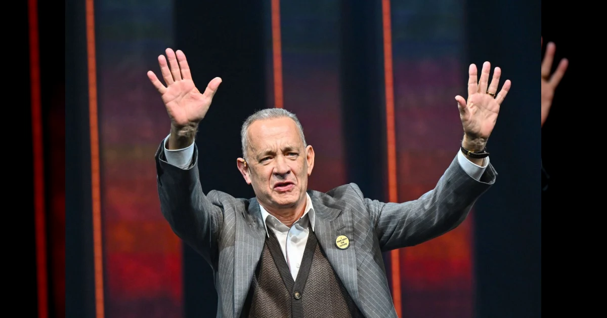 Tom Hanks ritratto in primo piano con espressione sorridente mentre compie 70 anni, simbolo di quattro decenni di cinema straordinario