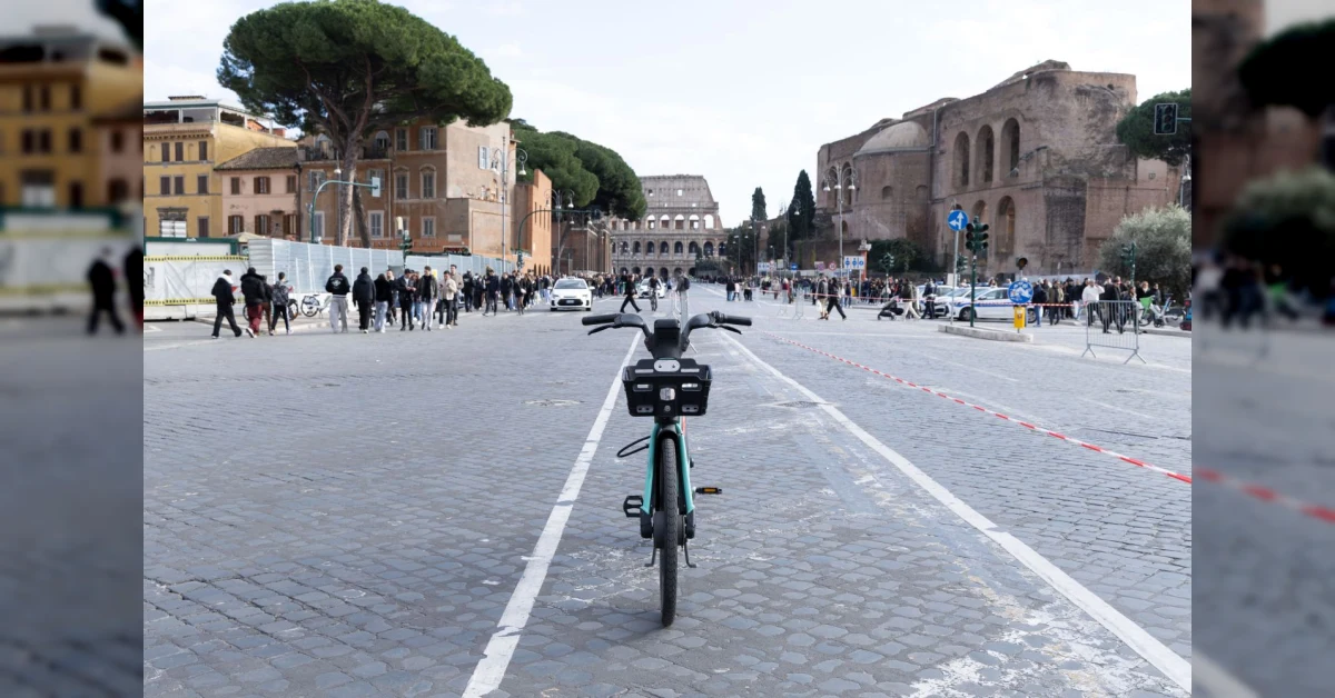Monopattini e bici elettriche in sharing a Roma davanti al Colosseo, con cartello Metrebus