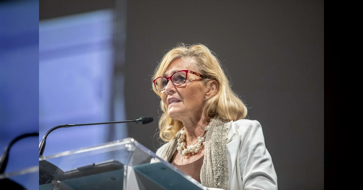 Diana Bianchedi ritratta in abito elegante con sfondo tricolore, simbolo della nuova capo delegazione della Nazionale italiana di calcio