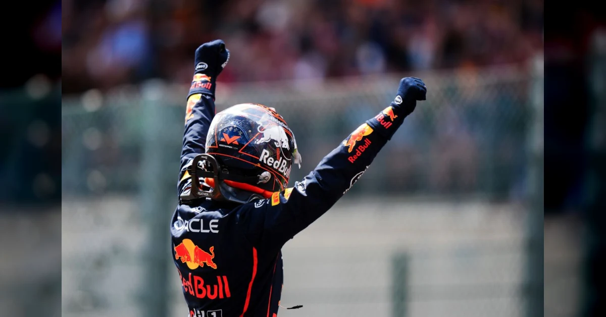 Max Verstappen con la tuta Red Bull sorride davanti alla sua monoposto durante l'annuncio del rinnovo contrattuale fino al 2030