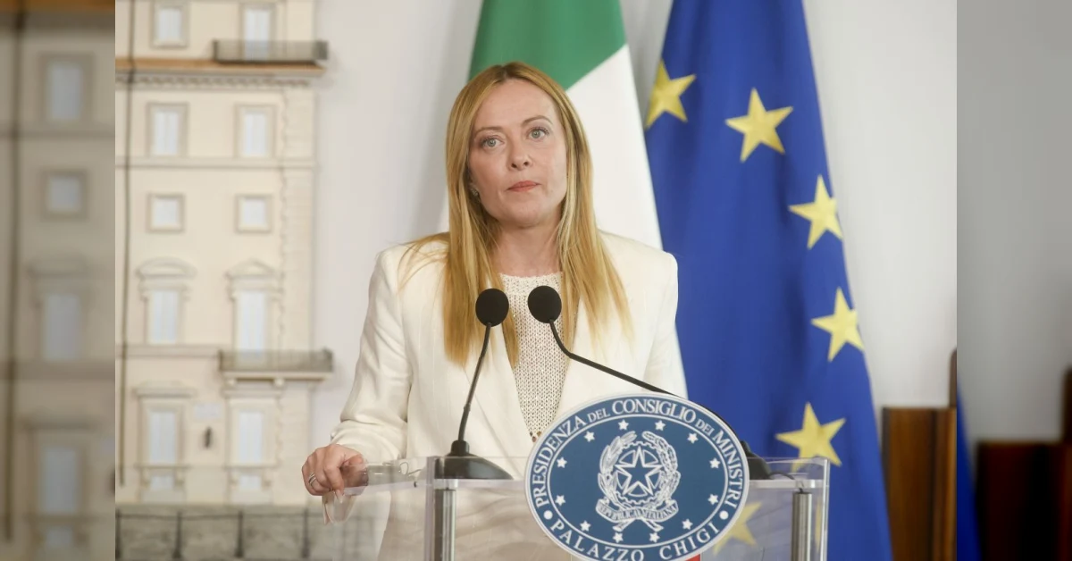 Giorgia Meloni in un colloquio con il NYT, con sfondo istituzionale, mentre discute di Trump e del Patto Ue su migrazione