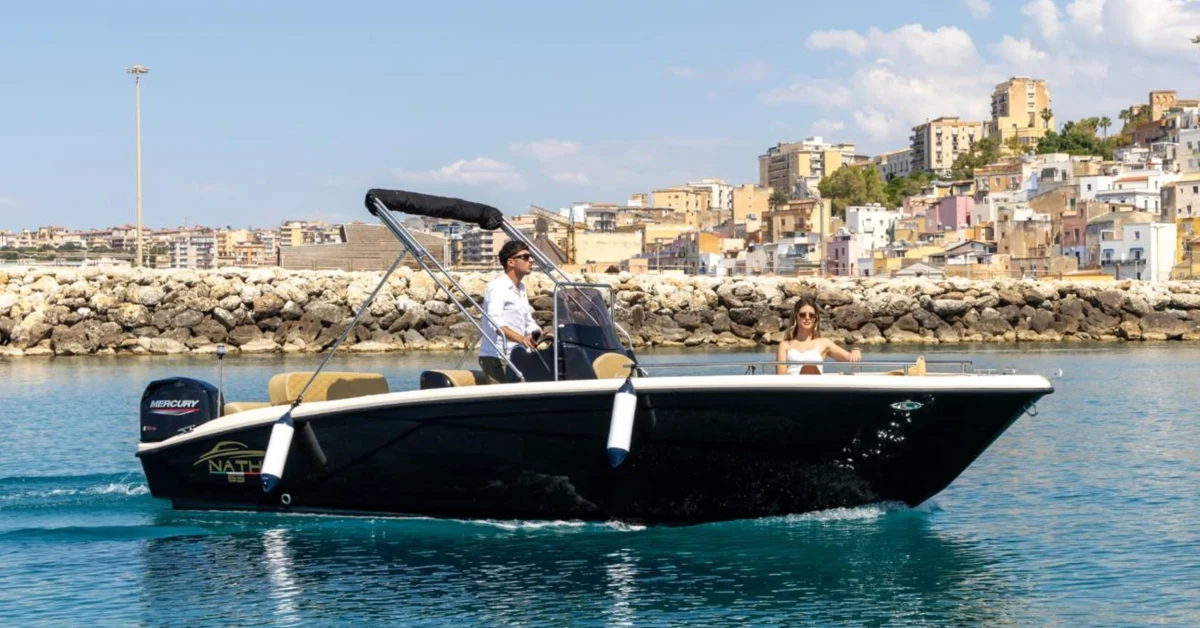 Barca a vela che solca il mare aperto verso l'orizzonte al tramonto, simbolo di libertà e giornata senza itinerari prestabiliti