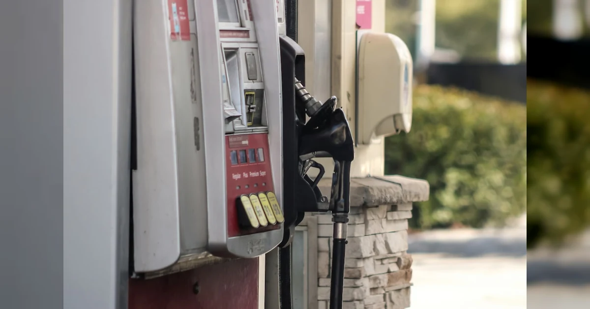 Automobilista controlla il serbatoio mentre un meccanico analizza il carburante per verificare la presenza di acqua