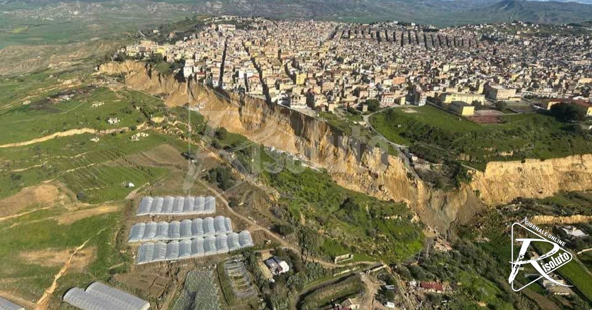 Crepa nel terreno sul versante della frana a Niscemi con case sullo sfondo
