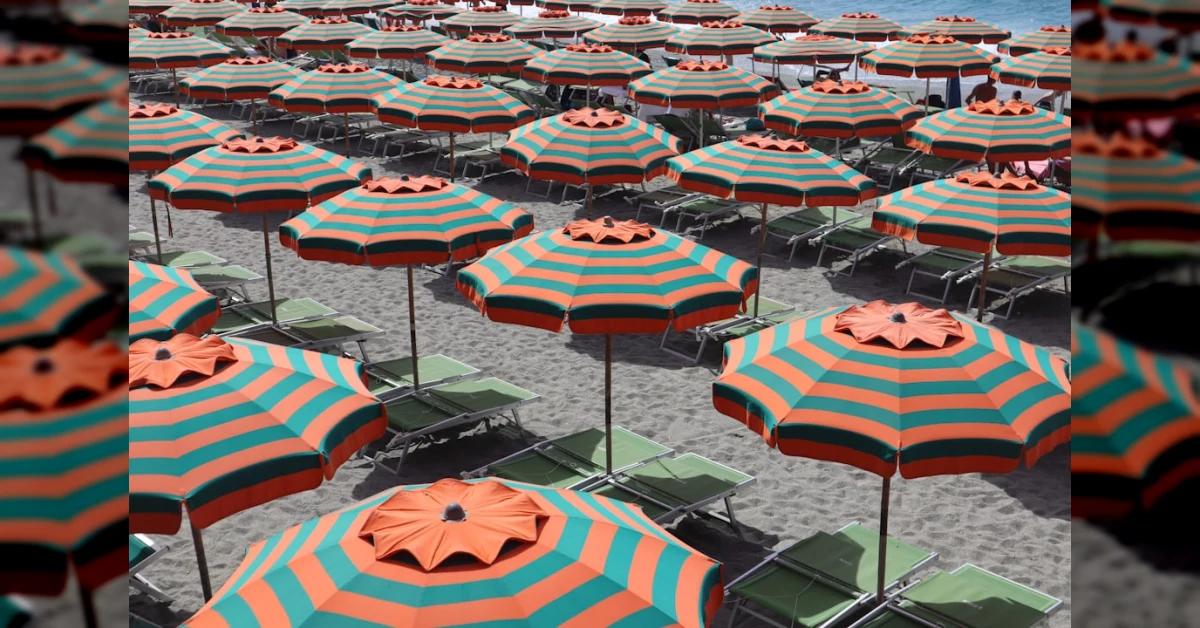 Spiaggia italiana con ombrelloni e gabbiani, tema concessioni demaniali