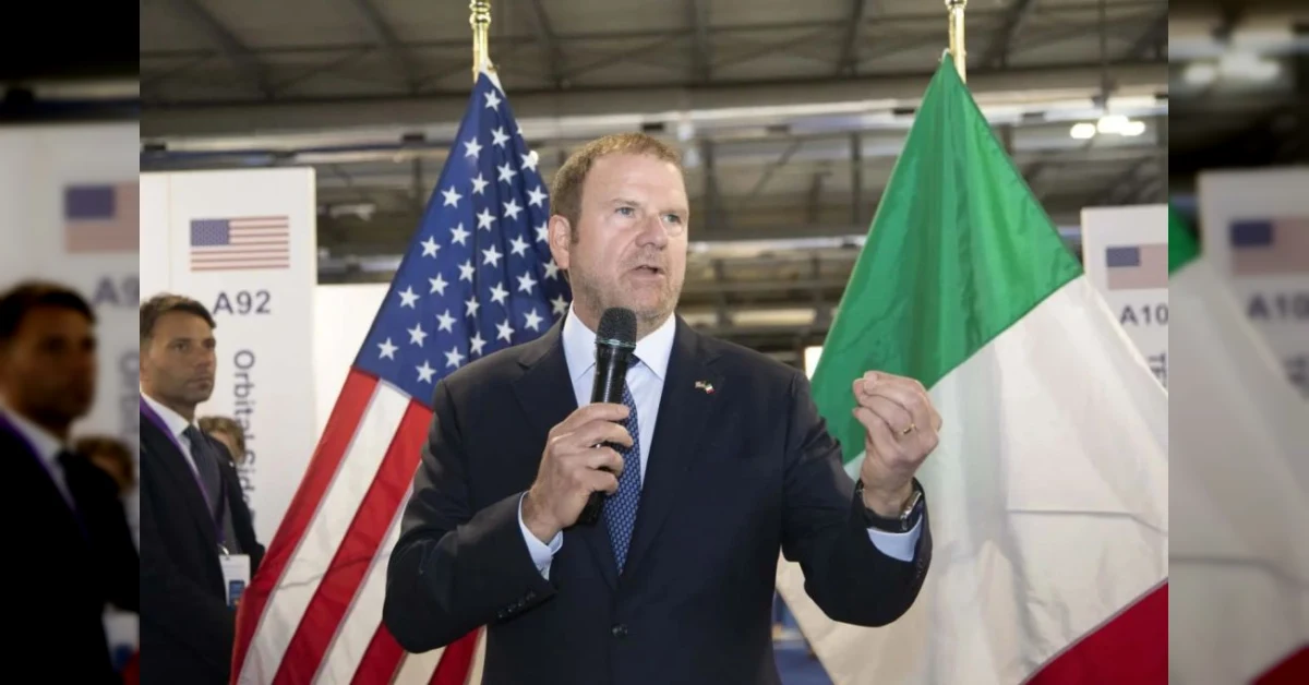 Tilman Fertitta, ambasciatore USA in Italia, in un incontro ufficiale con bandiere americana e italiana sullo sfondo