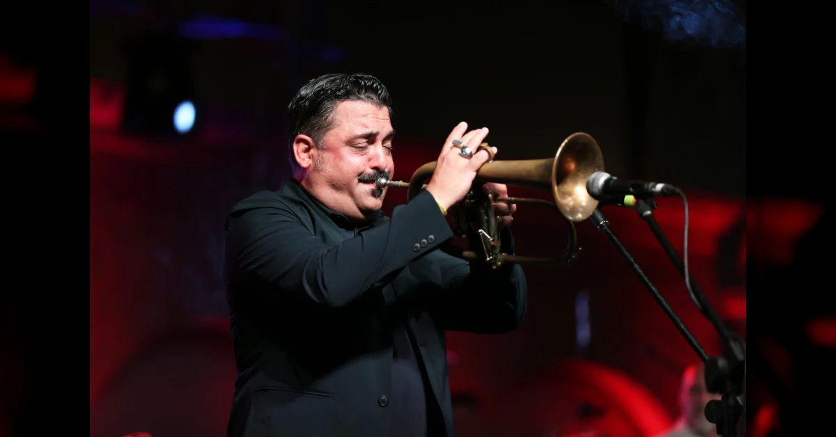 Roy Paci sul palco con la tromba durante un concerto dal vivo