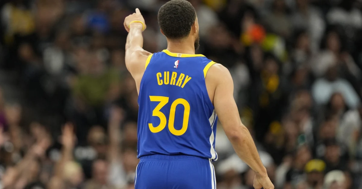 Stephen Curry sorride con la maglia dei Golden State Warriors durante una partita NBA