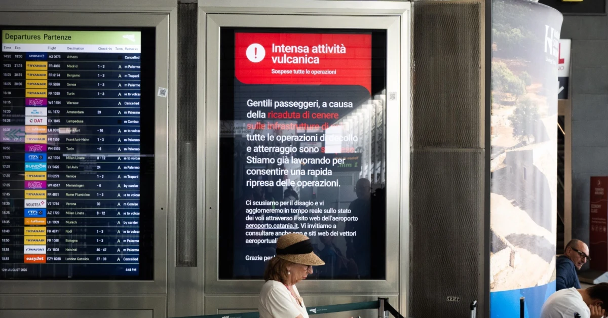 Aereo a terra all'aeroporto di Catania con nube di cenere dell'Etna sullo sfondo