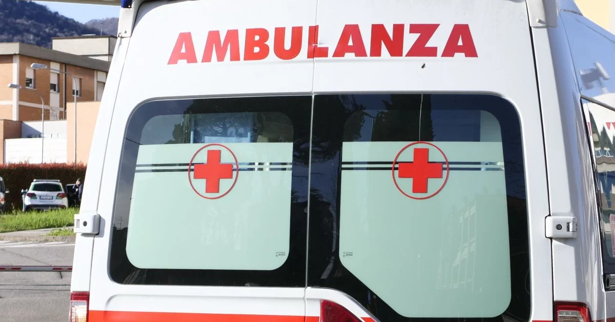 Auto della polizia e nastro di isolamento in strada di notte a Torino dopo investimento