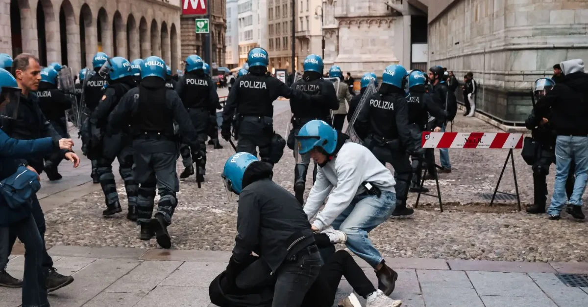 Forze dell'ordine in tenuta antisommossa nel centro di Milano durante i disordini con giovani